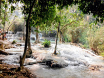 Cascatas em vários níveis nas Kuang Si Falls no Laos, com água azul-turquesa entre árvores da selva